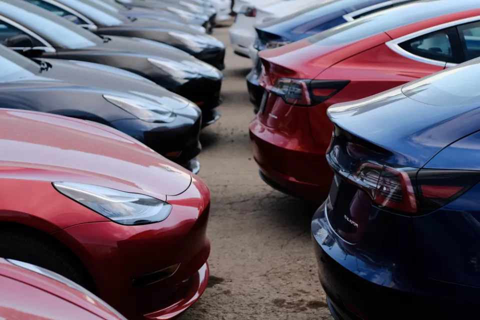 Close-up of multiple black and red Tesla cars parked in a lot